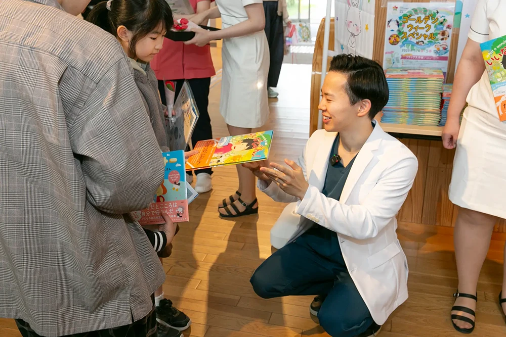子どもへ絵本を配布する串田大治医師
