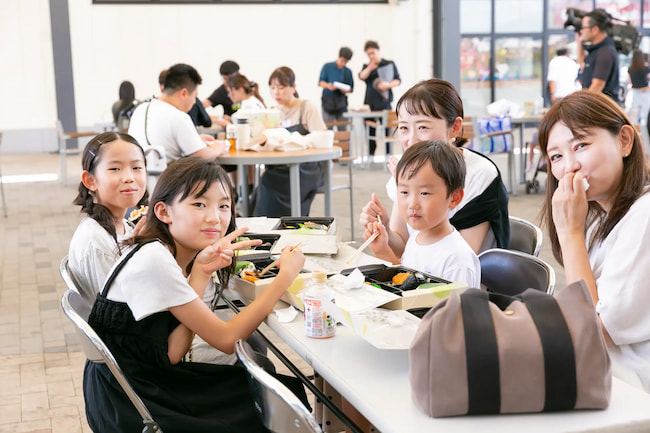 ぼっけぇ元気おにぎり箱を食べる来場者